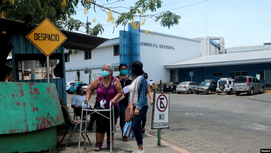 Un paciente camina con una familiar tras realizar una consulta en el Hospital Alemán Nicaraguense durante el mayor brote de coronavirus en abril del 2020.