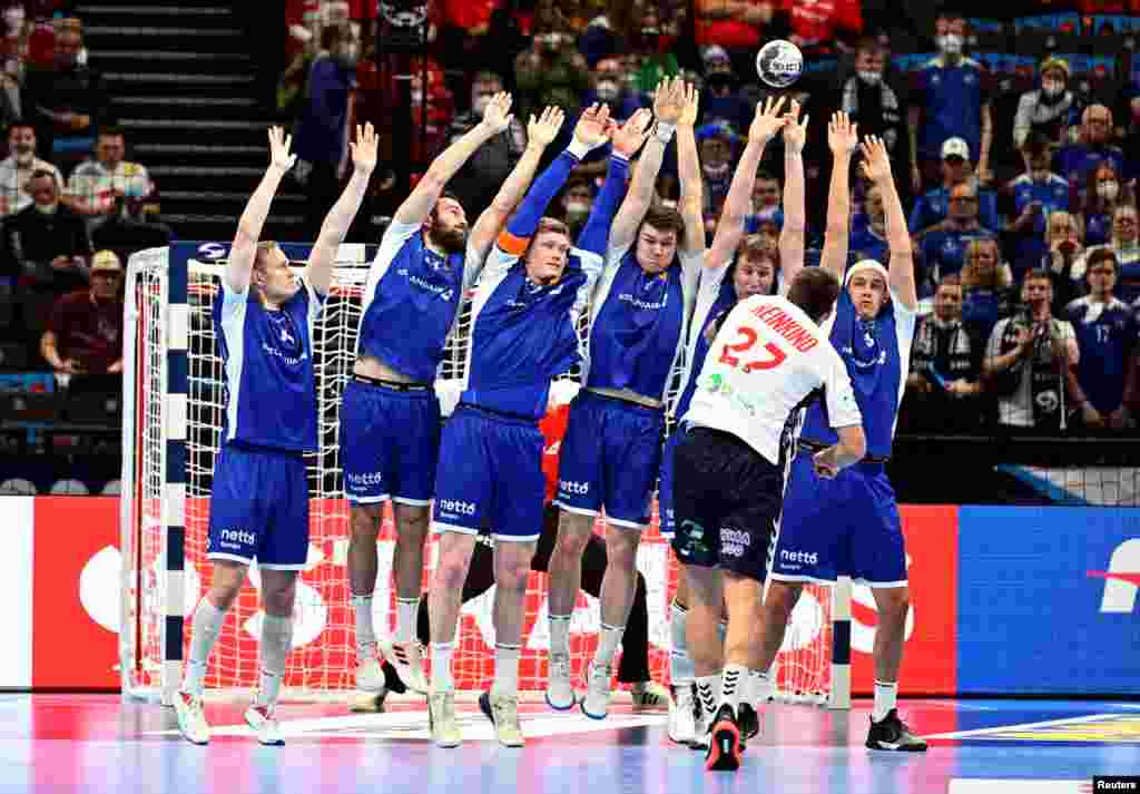 Iceland players form a defensive wall against Norway's Harald Reinkind during a placement match in the EHF 2022 Men's European Handball Championship, at the Budapest Handball Arena, in Budapest, Hungary.