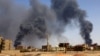 FILE PHOTO: Man walks while smoke rises above buildings after aerial bombardment in Khartoum North. REUTERS/Mohamed Nureldin Abdallah/File Photo