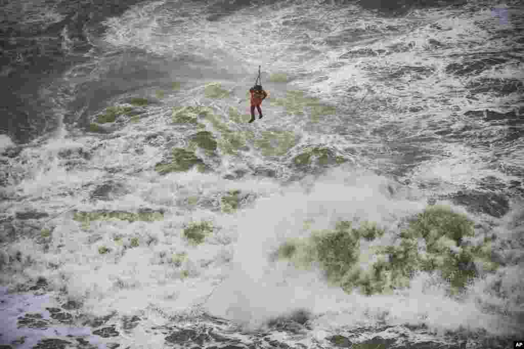 A crew member of a cargo ship that ran aground off the Black Sea coast of Sile, Turkey, is rescued with the help of a winch system extended from the shore.