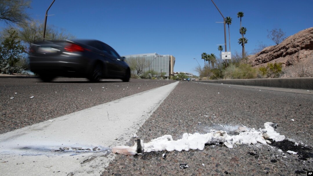 A vehicle goes by the scene of Sunday's fatality where a pedestrian was stuck by an Uber vehicle in autonomous mode, in Tempe, Ariz., Monday, March 19, 2018. (AP Photo/Chris Carlson)