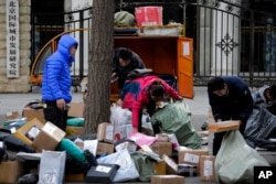 Delivery workers sort boxes of goods for their customers outside the capital city development academy in Beijing, China, Oct. 30, 2018. Surveys showed manufacturing in China weakened in December.