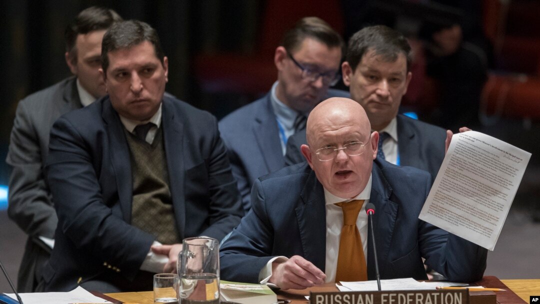 FILE - Russian Ambassador to the United Nations Vassily Nebenzia holds up a copy of a report as he speaks during a Security Council meeting at United Nations headquarters in New York, April 5, 2018.