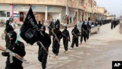 FILE - This undated image posted on a militant website shows fighters from the al-Qaida linked Islamic State of Iraq and the Levant (ISIL) marching in Raqqa, Syria.