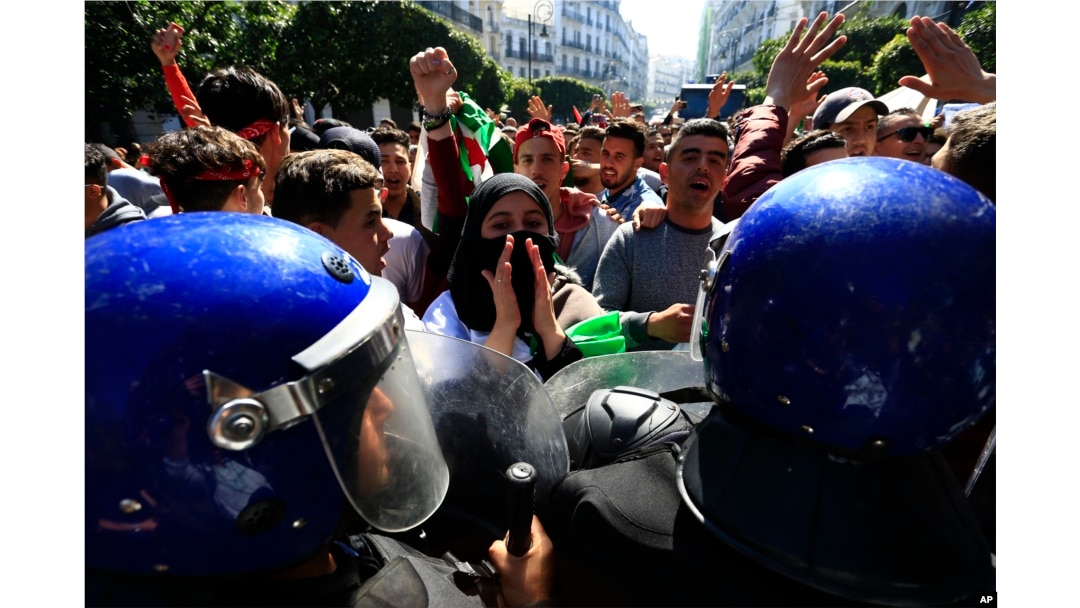 High school students face riot police officers as they protest in Algiers, Algeria, March 12, 2019.