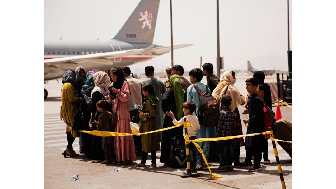 In this photo provided by the U.S. Marine Corps, civilians prepare to board a plane during an evacuation at Hamid Karzai International Airport, Kabul, Afghanistan, Wednesday, Aug. 18, 2021.