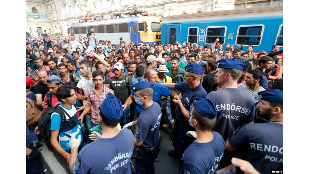Migrants face Hungarian police in the main Eastern Railway station in Budapest, Hungary, Sept. 1, 2015.