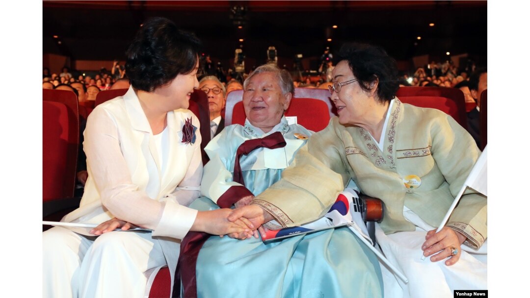 문재인 대통령 부인 김정숙(왼쪽) 여사가 15일 세종문화회관에서 열린 제72주년 광복절 경축식에서 일본군 위안부 피해자 길원옥(가운데)ㆍ이용수 할머니의 손을 잡고 이야기를 나누고 있다.