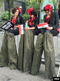 Women on stilts cheer for Egyptian President Abdel Fattah el-Sissi (VOA photo - C. Presutti).