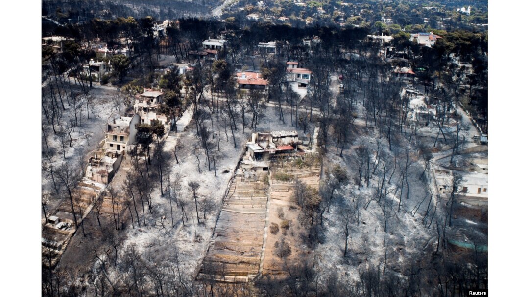 FILE - An aerial view shows burnt houses and trees following a wildfire in the village of Mati, near Athens, Greece, July 25, 2018.
