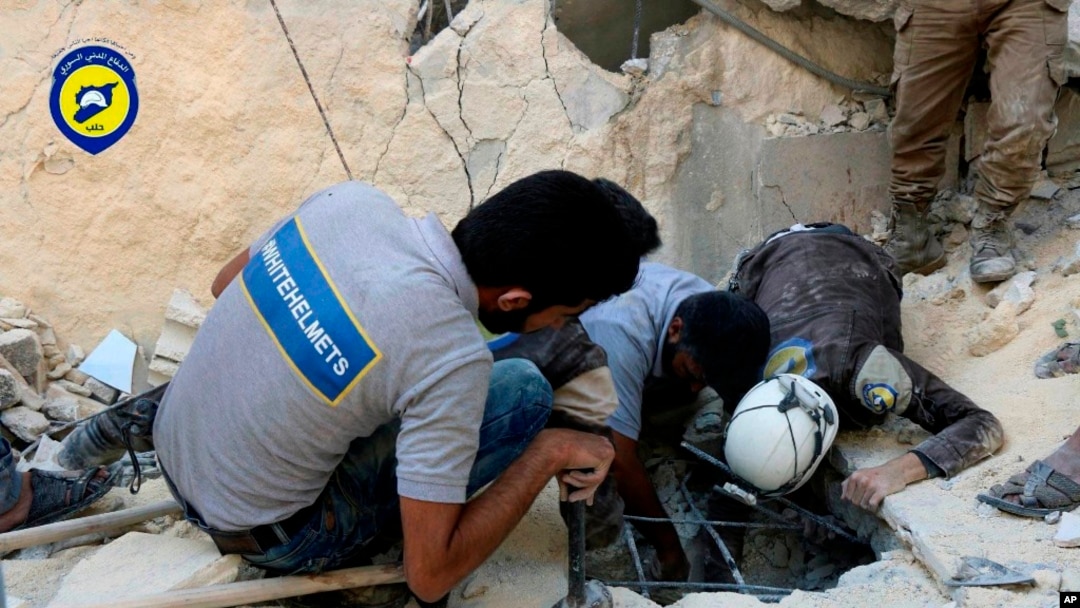 El grupo de Defensa Civil sirio conocido como los Cascos Blancos y los trabajadores de Defensa Civil siria buscan personas en Aleppo al este de Siria después de un ataque aéreo.