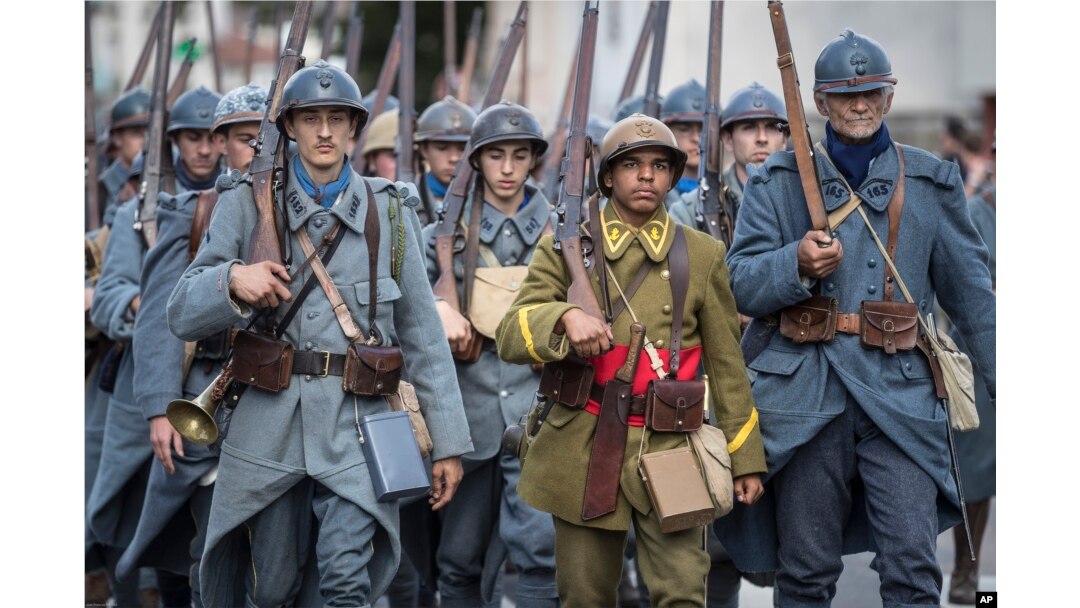FILE - Men dressed in WWI uniforms march during a parade, part of a reconstruction of the WWI battle of Verdun, Aug. 25, 2018, in Verdun, eastern France.