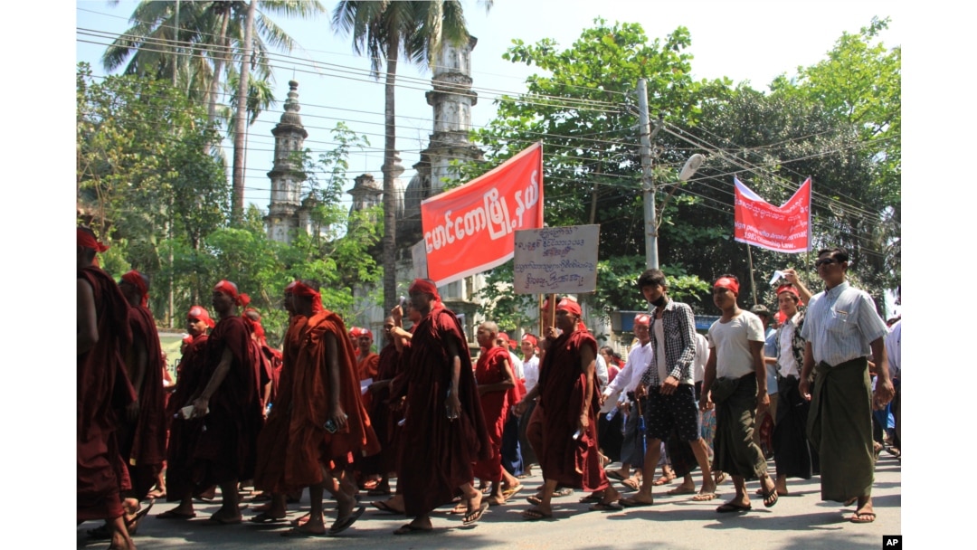 Hard-line Buddhists walk by a mosque during a protest march, led by Rakhine State's dominant Arakan National Party, against the government's plan to give citizenship to some persecuted Rohingya Muslims, March 19, 2017.