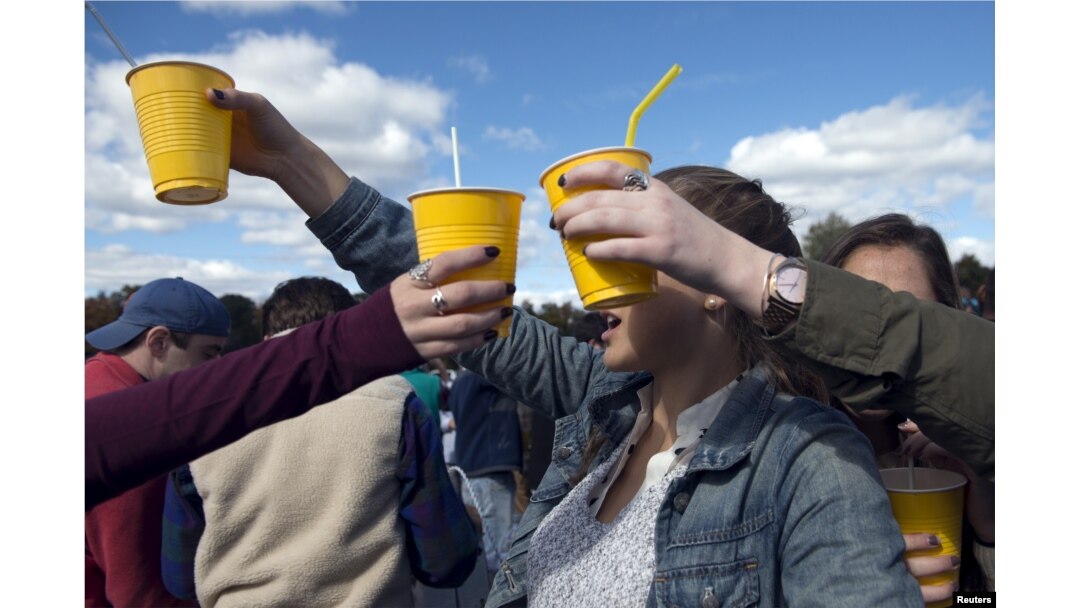 FILE - Revelers hold up yellow plastic cups during party in New Jersey, Oct. 17, 2015.