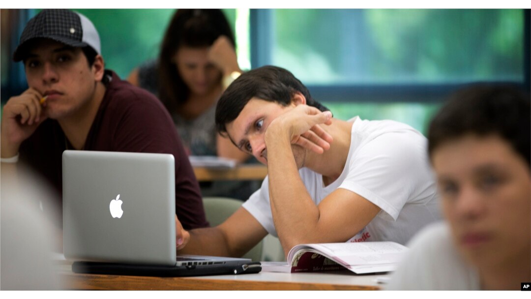 In this Sept. 9, 2013 photo, University of Miami student Gabriel Dias studies the daily lesson plan on his computer during a Spanish class in Coral Gables, Florida.