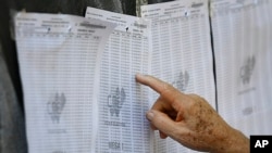 Un hombre busca su número de identificación en una lista de votantes durante un simulacro de votación en la escuela secundaria Andrés Bello en Caracas. Octubre 10, 2021.