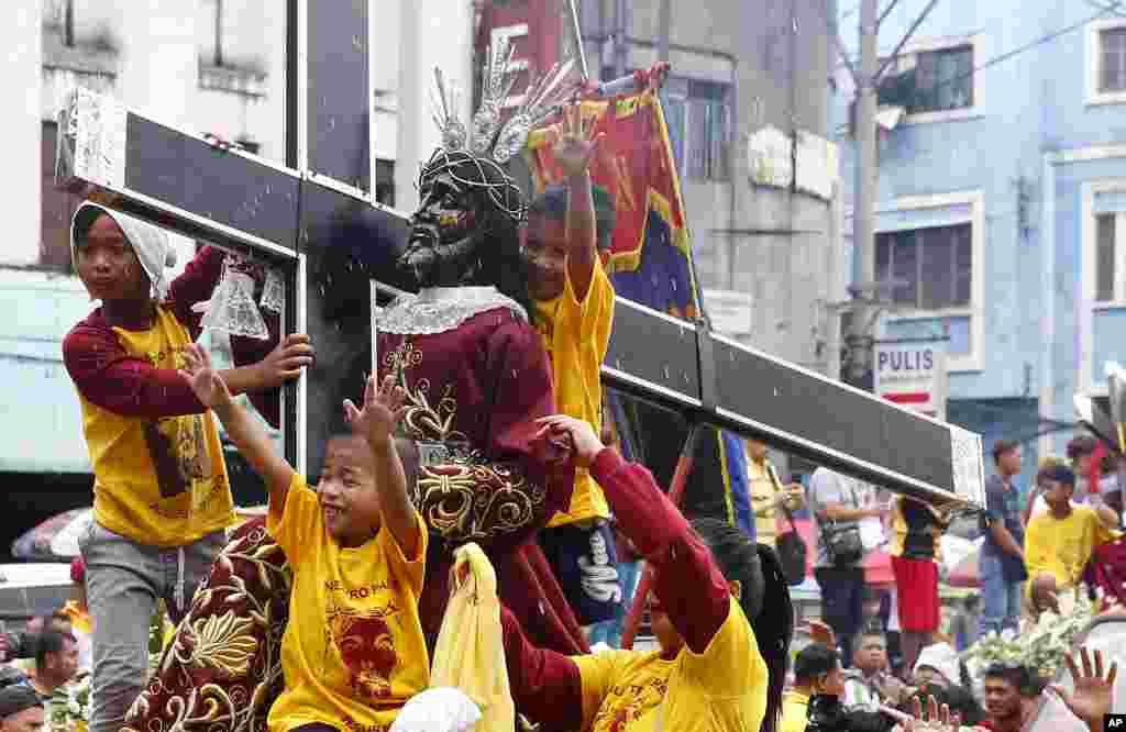 Thousands of replicas of the image of the Black Nazarene are blessed with holy water during the traditional blessing ahead of Wednesday's celebration of the Feast of the Black Nazarene, in Manila, Philippines.