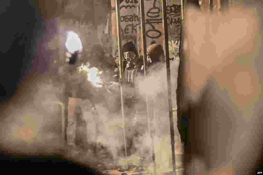 Protestors hold petrol bombs during a demonstration in Athens on Dec. 6, 2018 to commemorate the 10th anniversary of fatal shooting of a teenager which sparked major riots in Greece in 2008.