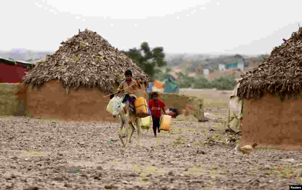Boys transport water jerrycans in an improvised camp for internally displaced people near Abs of the northwestern province of Hajja, Yemen.