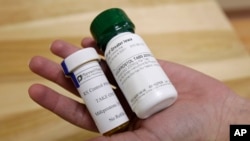 FILE - Bottles of abortion pills mifepristone, left, and misoprostol, right, at a health center in Des Moines, Iowa, Sept. 22, 2010. A federal appeals court has preserved access to an abortion drug for now with some restrictions. (AP Photo/Charlie Neibergall, File)