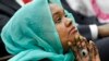 Deeqo Jibril of Boston, the founder of the Somali Community and Cultural Association, listens as President Barack Obama speaks at the White House Summit on Countering Violent Extremism, Feb. 18, 2015.