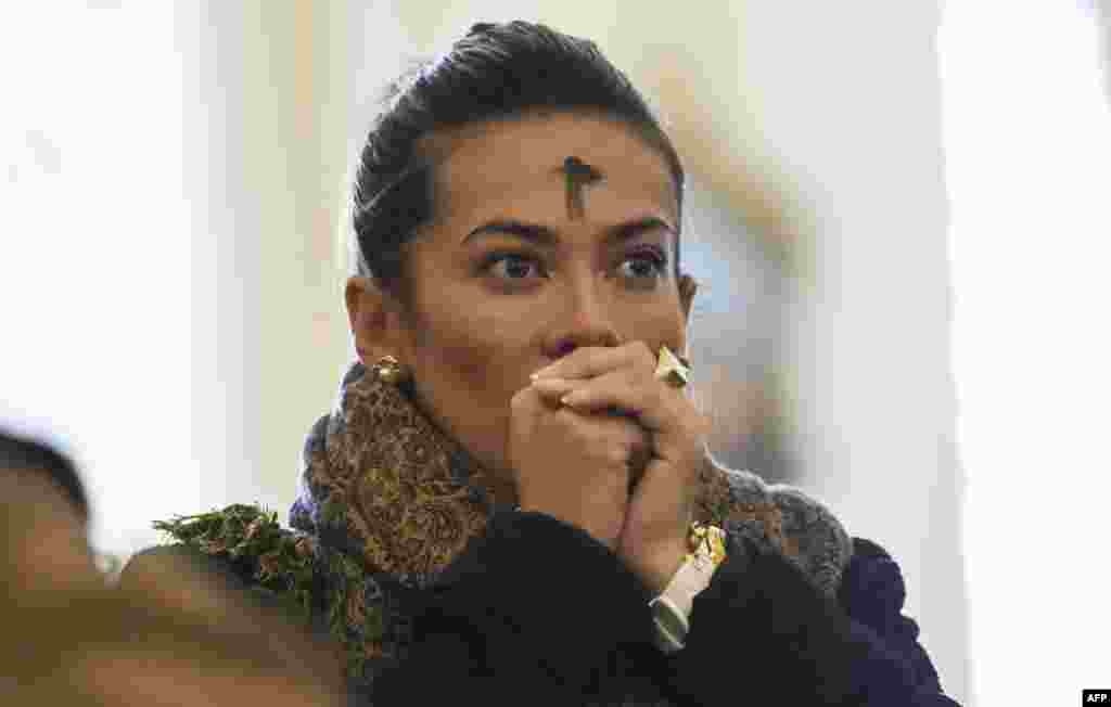 A Catholic faithful with her forehead marked with ash prays during the celebration of Ash Wednesday in Bogota, Colombia.