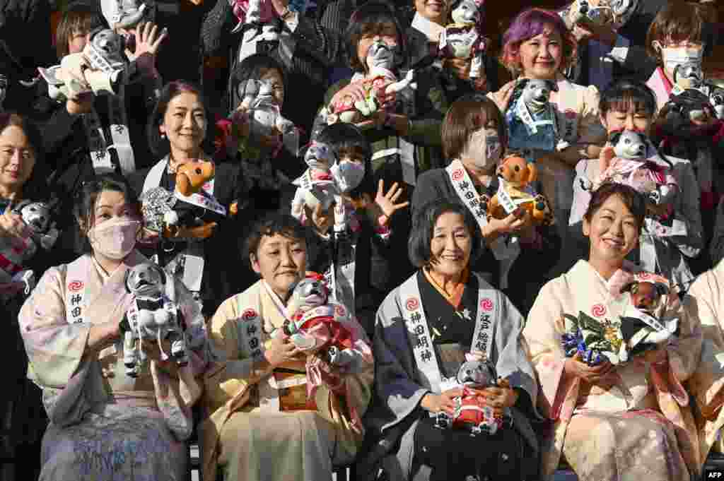 Owners of Sony's pet robot Aibo pose for a commemorative photo during an event to celebrate Aibo's third birthday and wish for good health in the future at Kanda shrine in Tokyo.