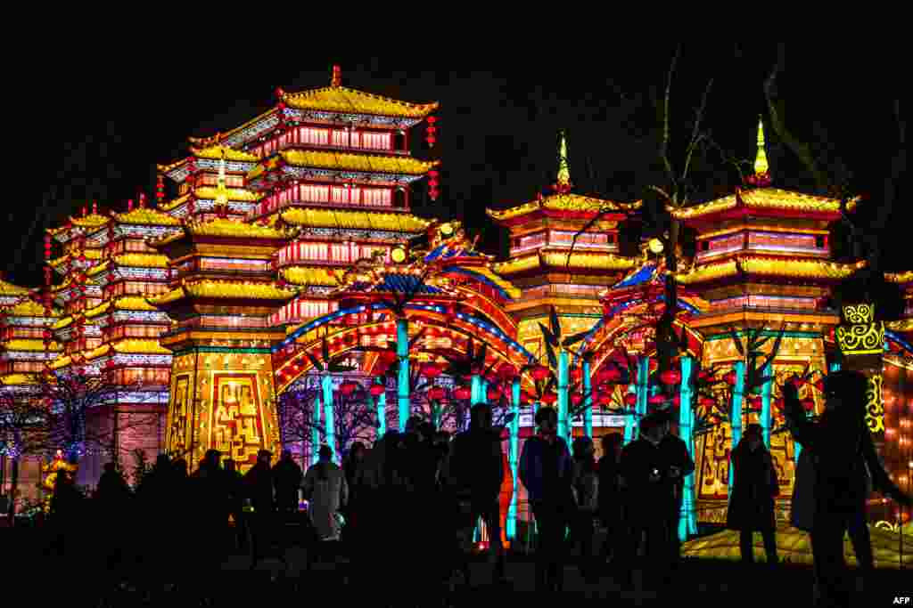 Visitors view monumental silk lanterns depicting a palace, installed at the Foucaud Park in Gaillac, southwestern France, during the Lantern Festival, Dec. 12, 2018.