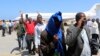 FILE- Deported Somali nationals gesture as they arrive at the airport in Somalia's capital of Mogadishu, April 9, 2014. Sixty-eight Somalis arrived in Mogadishu Friday, having been deported by U.S. immigration authorities.