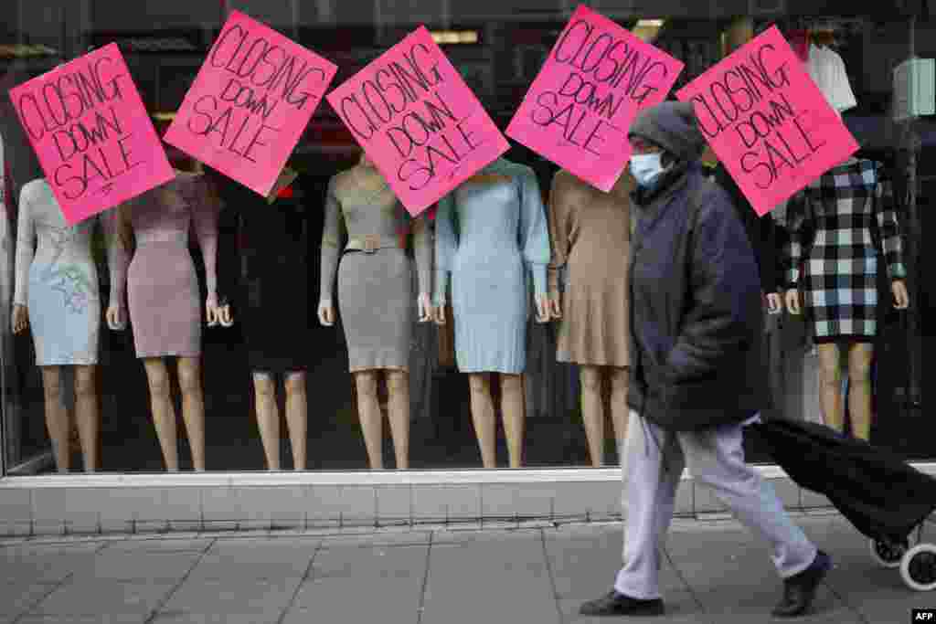 A pedestrian walks past "Closing Down Sale" signs in the window of a clothes shop in Walthamstow, east London. The UK government announced a £9 billion package to offset soaring energy bills.