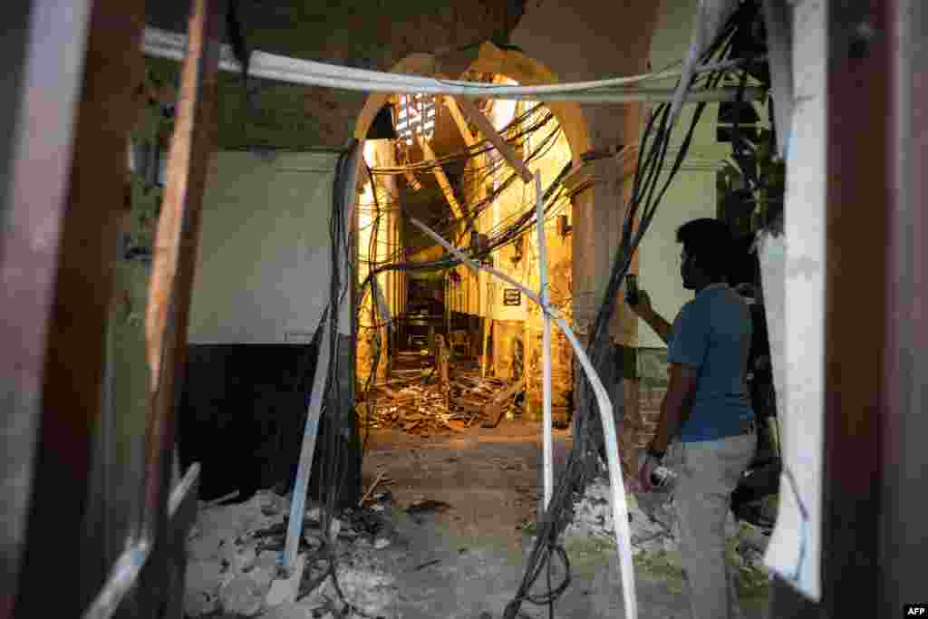 A Sri Lankan man uses his mobile phone to take pictures inside St. Anthony's Shrine in Colombo following a series of bomb blasts targeting churches and luxury hotels on Easter Sunday.