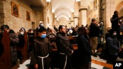 Viongozi wa dini wahudhuria ibada ya mkesha wa Krismas katika Kanisa la Mtakatifu Catherine, Bethlehem, katika eneo linalokaliwa kwa mabavu na Israeli Ukingo wa Magharibi Dec. 25, 2021.(Mussa Qawasma/Pool Photo via AP)
