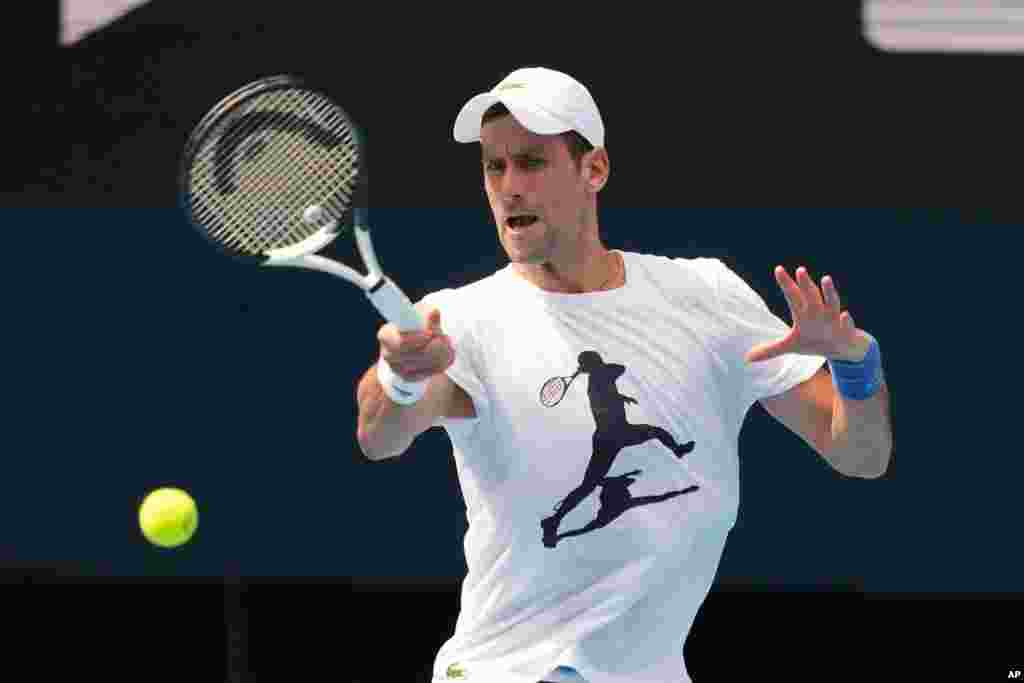 In this photo provided by Tennis Australia, the defending champion Serbia's Novak Djokovic, practices at the Rod Laver Arena ahead of the Australian Open at Melbourne Park in Melbourne, Australia.