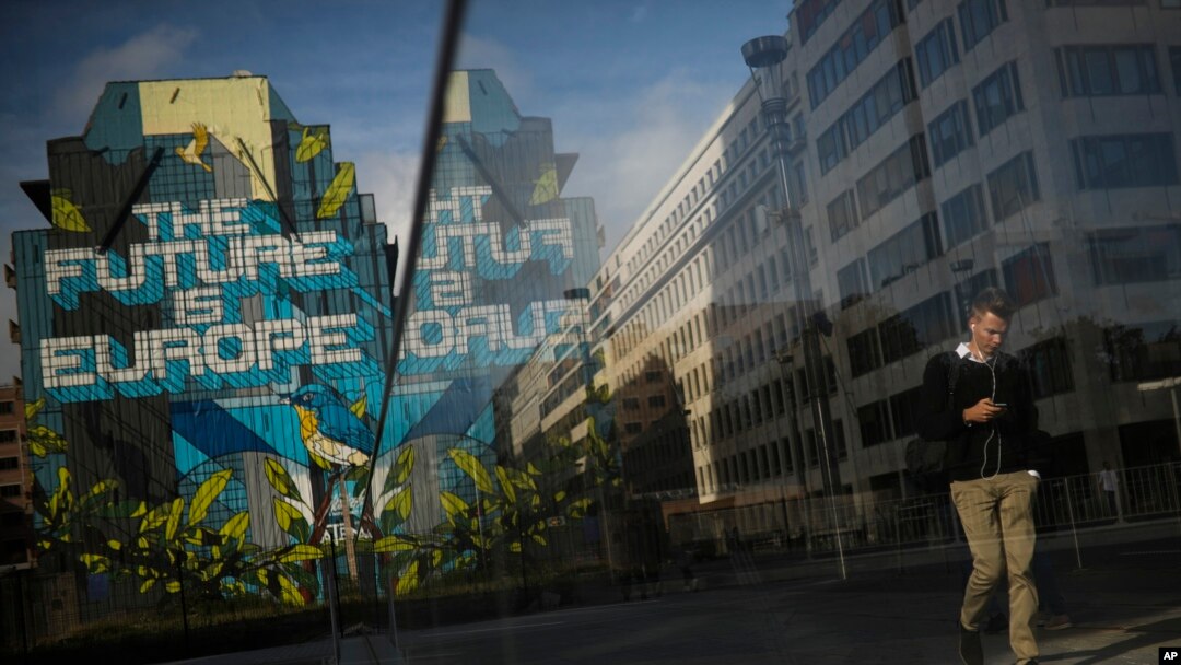 People walk past next to a pro-Europe street art painting in the European quarter in Brussels, Oct. 25, 2019.