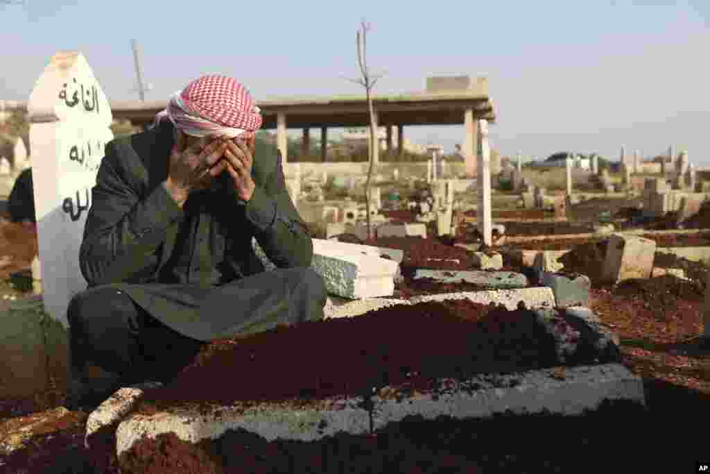 Mohammad al-Mahmoud, father of a seven-day-old baby, Fatima, cries at her grave in Haranbush village, Idlib province, Syria. Doctors say Fatima died from cold after she was brought to a hospital from a refugee camp near the village of Haranbush.