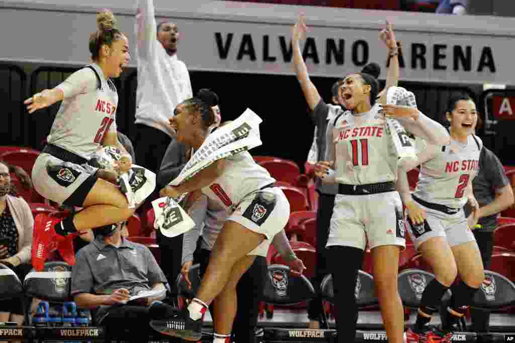 North Carolina State's Madison Hayes (21), Diamond Johnson (0), Jakia Brown-Turner (11) and Raina Perez (2) celebrate their win over Towson in an NCAA college basketball game, Nov. 15, 2021, in Raleigh, North Carolina.