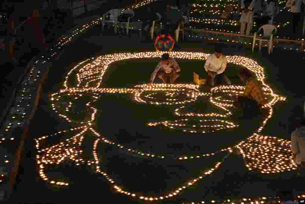 Indians makes formation of Bhim Rao Ambedkar with earthen lamps to mark Ambedkar's death anniversary in Ahmadabad. Ambedkar was one of the country's prominent freedom fighters and the chief architect of the Indian Constitution that outlawed discrimination based on caste.