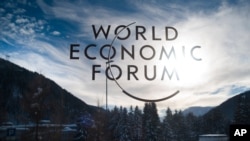 The sign of the World Economic Forum, WEF, is displayed at an entrance door at the congress center at the eve of the meeting in Davos, Sunday, Jan. 20, 2019. (AP Photo/Markus Schreiber)