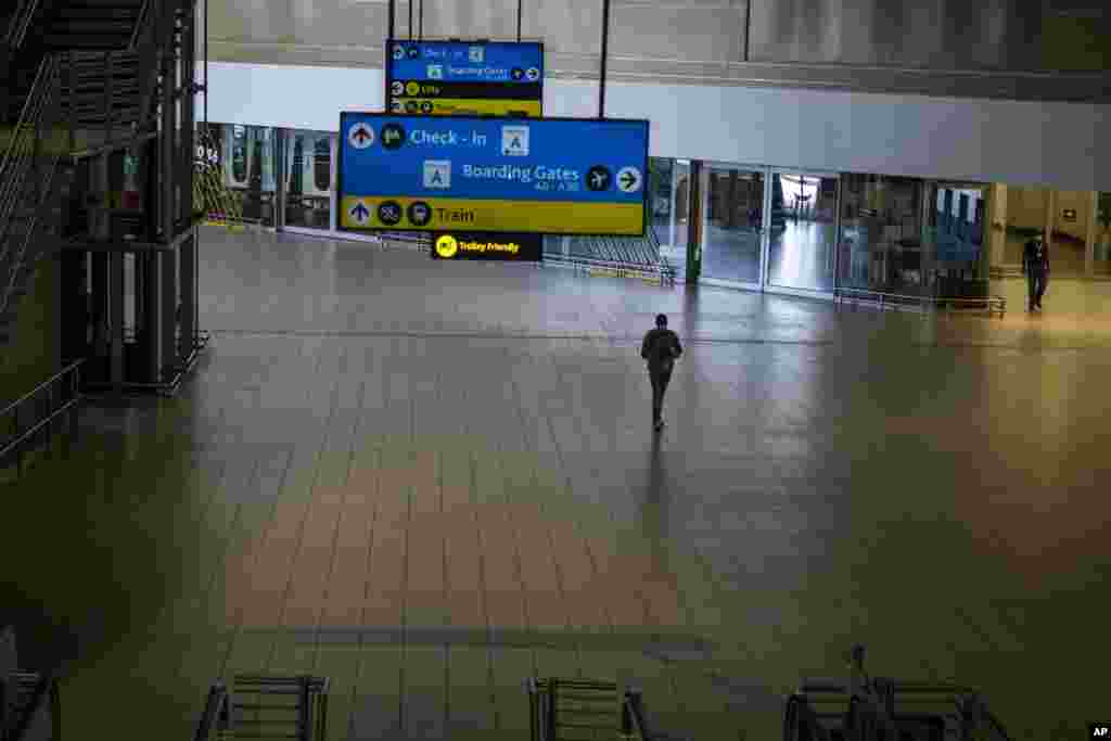 A man walks through a deserted part of Johannesburg's OR Tambo's airport, South Africa. The World Health Organization urged countries around the world not to impose flight bans on southern African nations due to concern over the new omicron variant.
