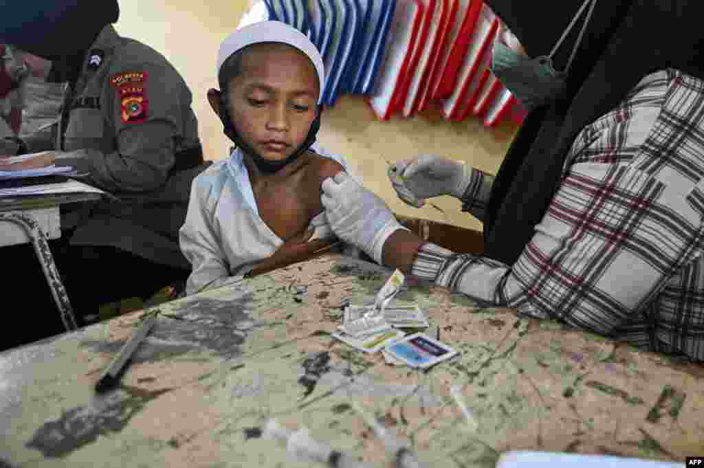 A student receives the Sinovac COVID-19 vaccine at a primary school in Darul Imarah, Aceh province, Indonesia.