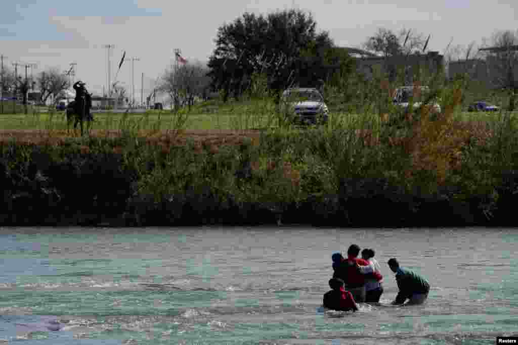 Migrants, seen from Piedras Negras, Mexico, try to cross the Rio Bravo River to reach the United States, Feb. 12, 2019.