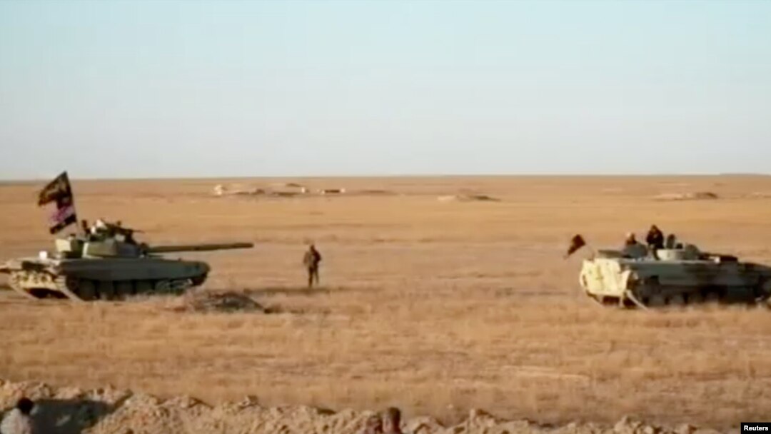 Armored vehicles take position in the middle of a desert near Syria border, Iraq in this still image taken from a video obtained by Reuters on Nov. 23, 2017. (Hashid Shaabi/Handout via Reuters TV) 