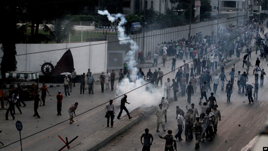 Pakistani protesters hurl back tear gas fired by police, unseen, to stop them from walking toward the U.S. consulate during a demonstration in Karachi, Pakistan, Sunday, Sept. 16, 2012.