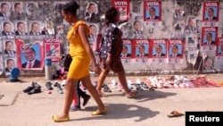Dos mujeres mozambicanas pasan frente a una valla que publicita las elecciones legislativas en Maputo, la capital, el 11 de octubre de 2019. 