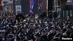 At crowded funeral for slain NYPD Officer Rafael Ramos, many officers turn their backs to shun New York City Mayor Bill de Blasio as he delivers eulogy, Dec. 27, 2014.
