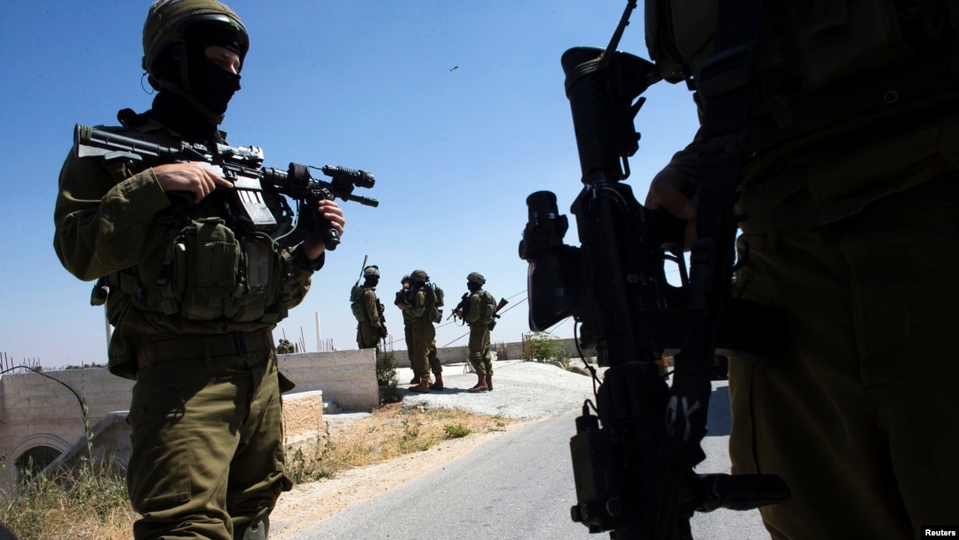 Israeli soldiers patrol during operation to locate three missing teenagers, in the West Bank city of Hebron, June 18, 2014.