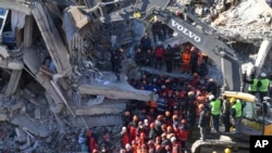 Rescue workers continue to look for people trapped under debris following a strong earthquake that destroyed several buildings on Friday, in Elazig, eastern Turkey, Jan. 26, 2020. 