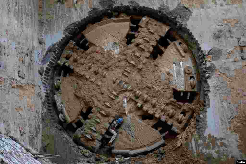 A construction worker comes through a Tunnel Boring Machine (TBM) breakthrough point after successfully building a tunnel for the metro train in Ahmedabad, India.