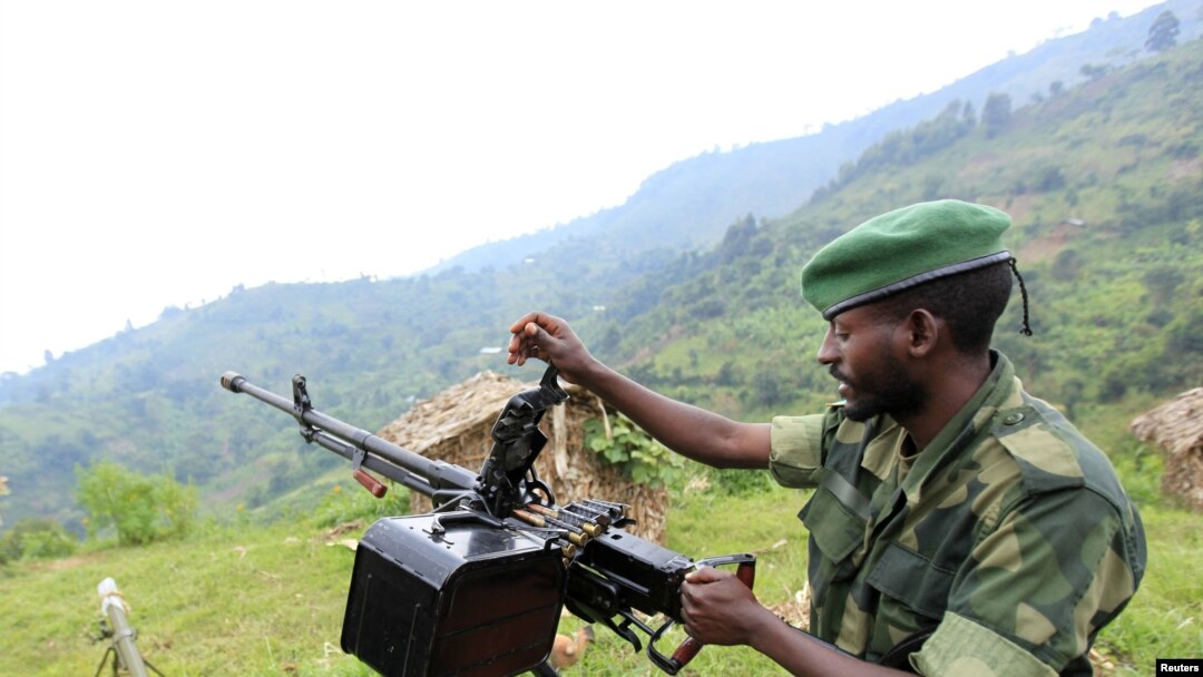 A M23 rebel fighter prepares his machine gun at their defense position in Karambi, eastern Democratic Republic of Congo (DRC) in north Kivu province, near the border with Uganda, July 12, 2012. 