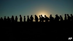 Migrantes que cruzaron el río Bravo (o Grande) y entraron a Estados Unidos desde México formados para ser procesados por la Oficina de Aduanas y Protección Fronteriza, el 23 de septiembre de 2023, en Eagle Pass, Texas. (AP Foto/Eric Gay, Archivo)